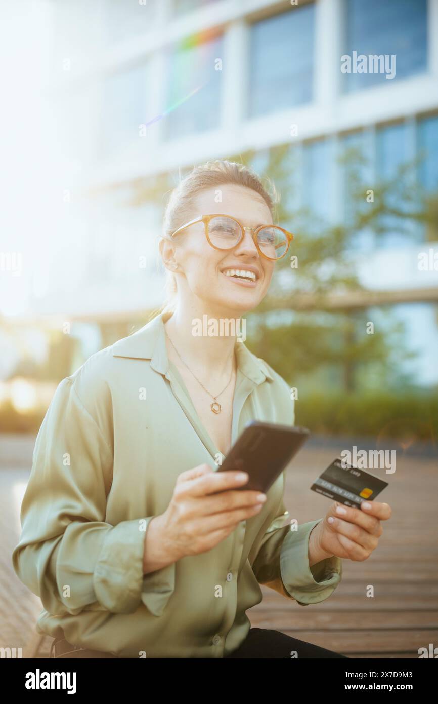smiling modern female employee near business center in green blouse and ...
