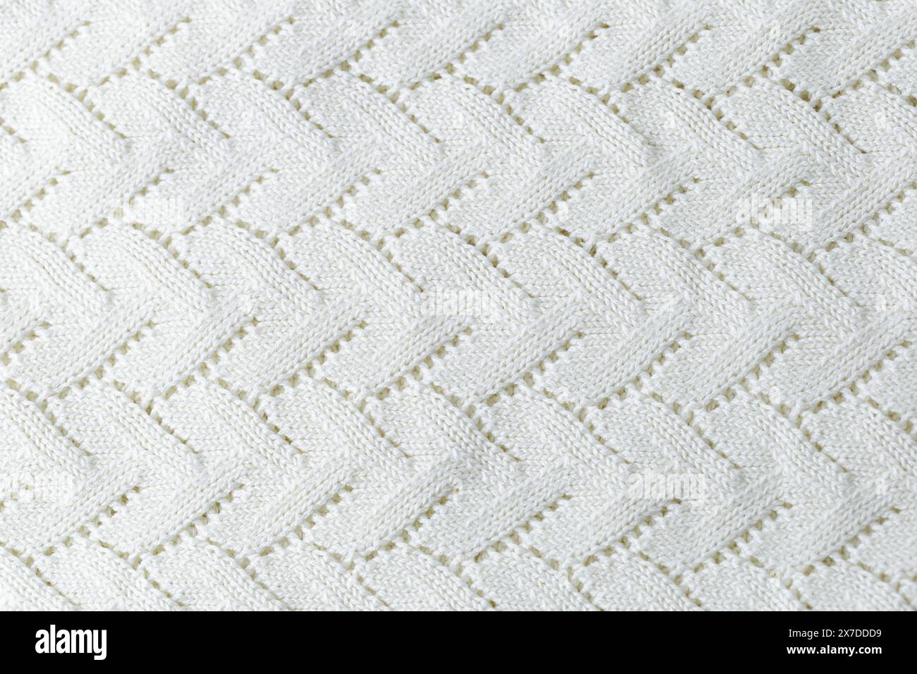 A white knit blanket with a zigzag pattern. Repetitive abstract pattern. Stock Photo