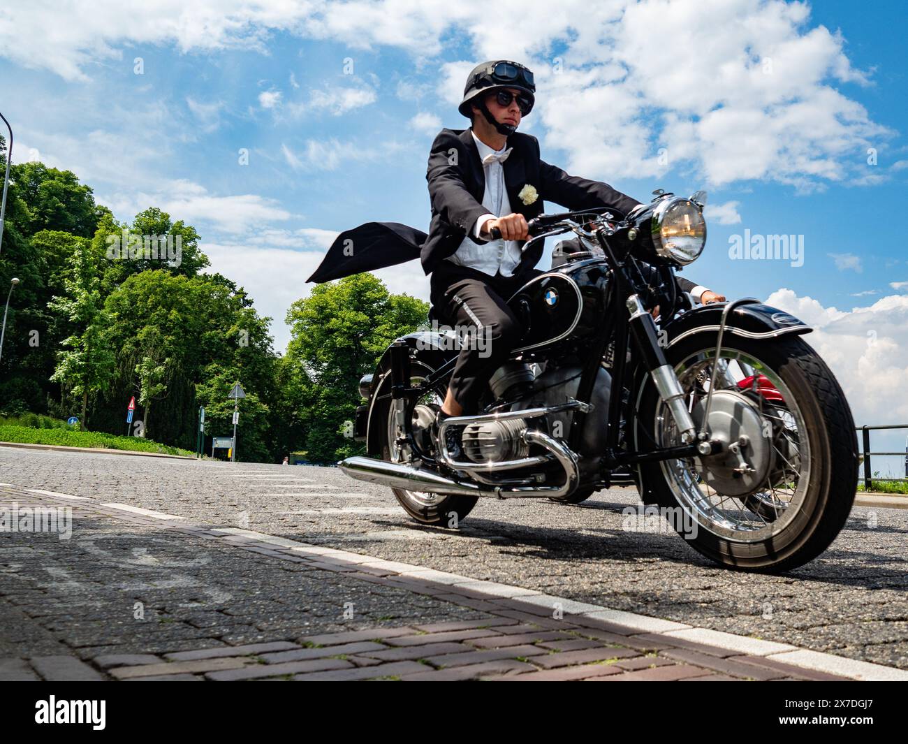 A man wearing a tuxedo jacket rides a motorbike. The Distinguished Gentleman's Ride unites classic and vintage-style motorcycle riders worldwide to raise funds and awareness for prostate cancer research and men's mental health. In Nijmegen more than two hundred motorcycle riders, raised around 30.000€.The Distinguished Gentleman's Ride (DGR) raises funds for The Movember Foundation, the leading global charity changing the face of men's health, to improve the lives of men through prostate cancer research and men's mental health initiatives. Stock Photo
