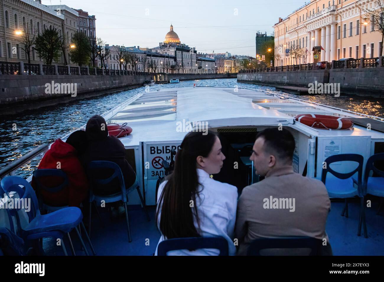 St. Petersburg, Russia. 18th May, 2024. A motor ship with tourists sails through the central canals of St. Petersburg against the backdrop of the dome of St. Isaac's Cathedral. Credit: SOPA Images Limited/Alamy Live News Stock Photo