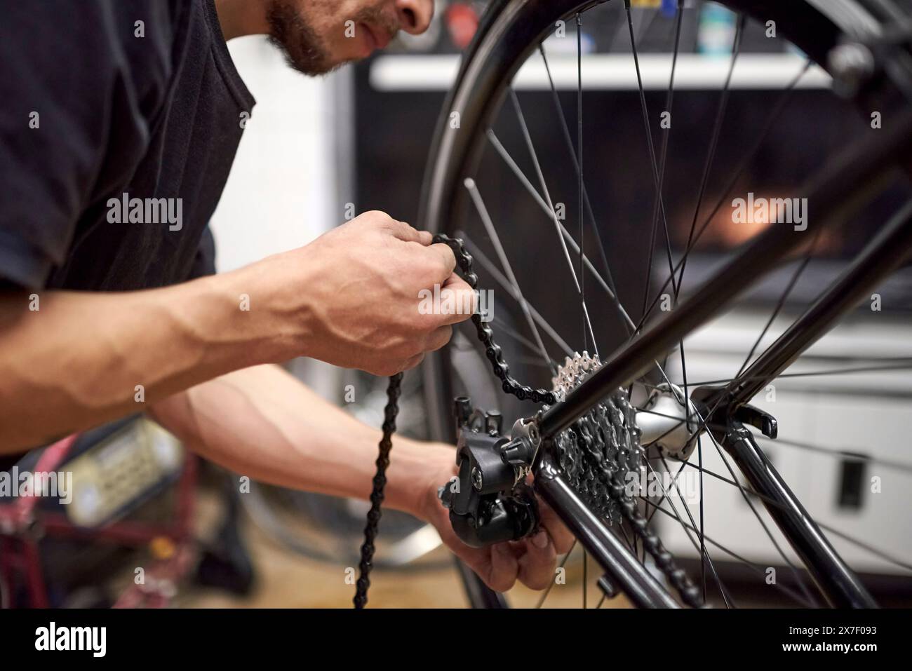 Repairman working: hispanic man putting the chain on a bicycle in his ...