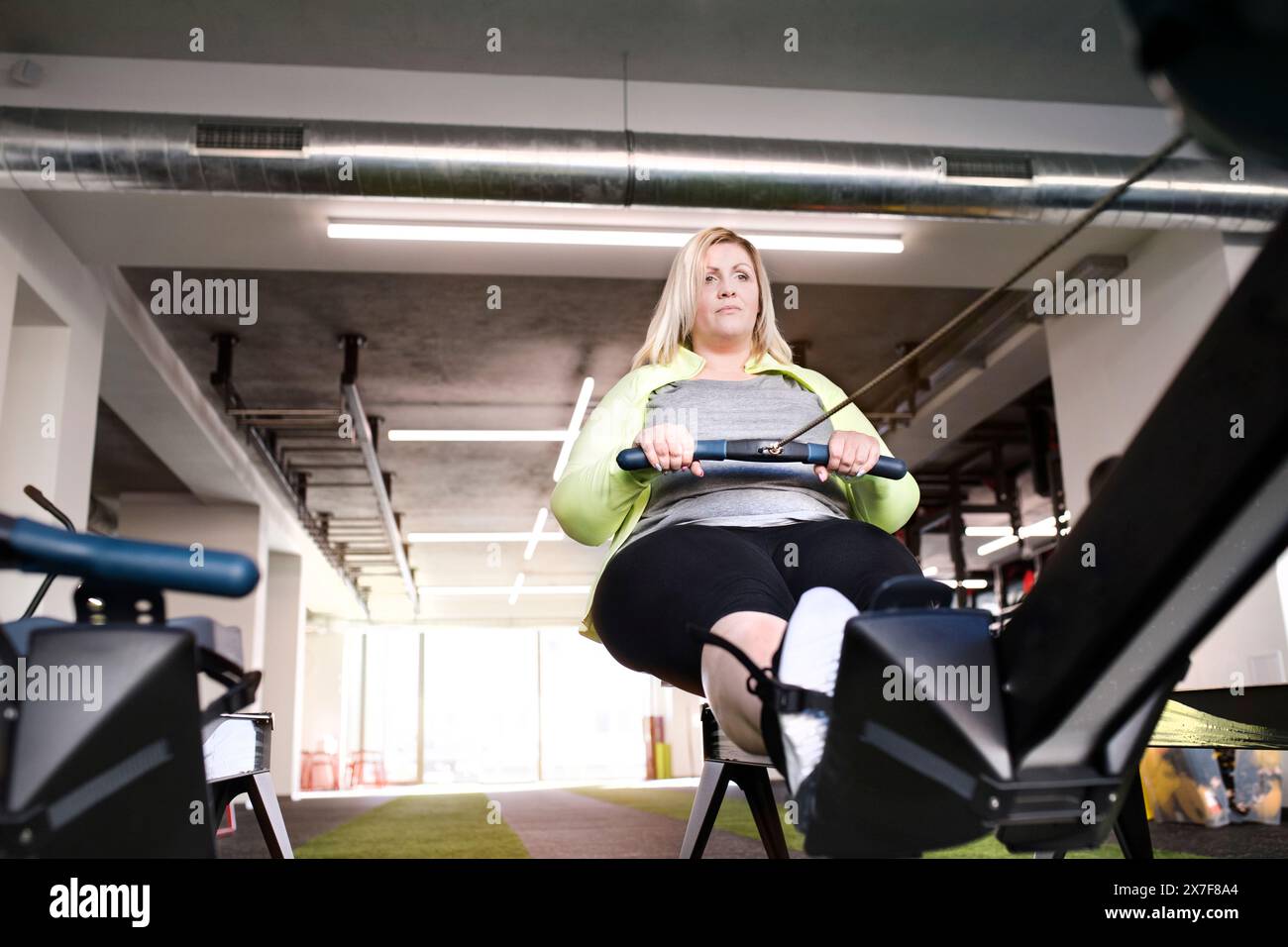 Overweight Rowing Woman exercising on rowing machine hi-res stock photography and images ...