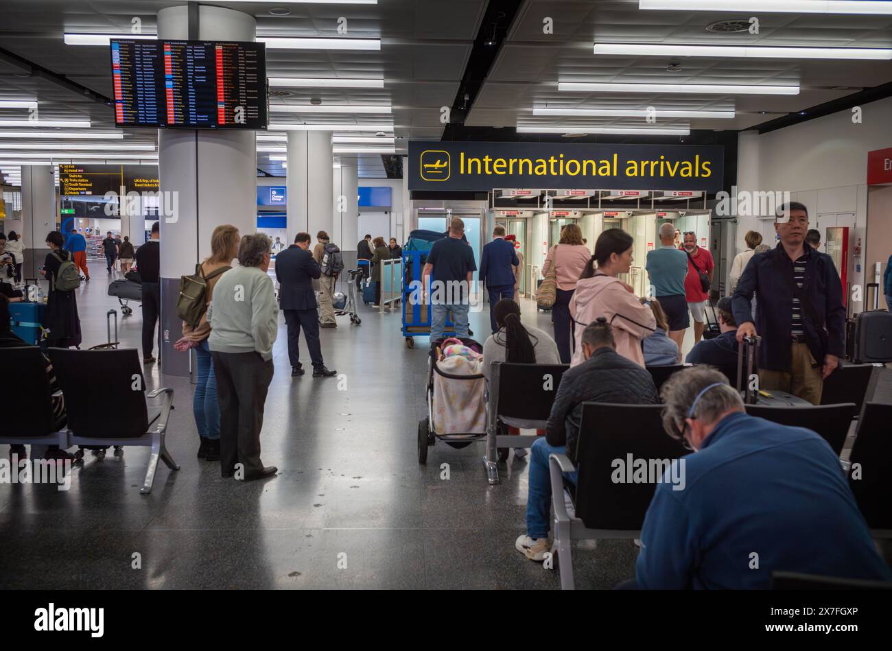 People wait for airline passengers to arrive at International Arrivals at London Gatwick Airport North Terminal, UK. Stock Photo