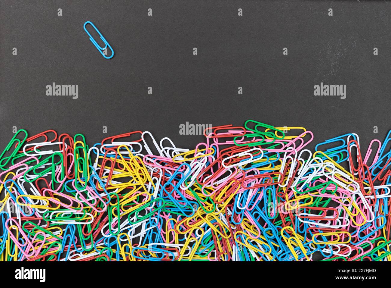 Black background with colorful paper clips and copy space Stock Photo