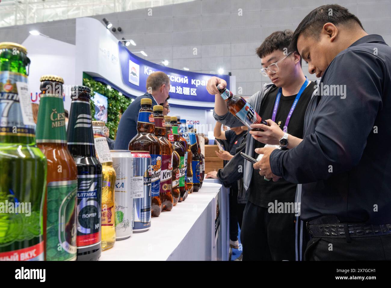 (240520) -- HARBIN, May 20, 2024 (Xinhua) -- Visitors buy beer from Russia during the eighth China-Russia Expo in Harbin, northeast China's Heilongjiang Province, May 20, 2024. Over 5,000 overseas buyers registered at the expo and representatives from 44 countries and regions participated in the expo. The exhibition area spans 388,000 square meters, showcasing more than 5,000 products in over 20 major categories from 10 sectors.  Held from May 16 to 21, the expo is also a gustatory feast where visitors can taste a wide array of food and beverages. (Xinhua/Xie Jianfei) Stock Photo