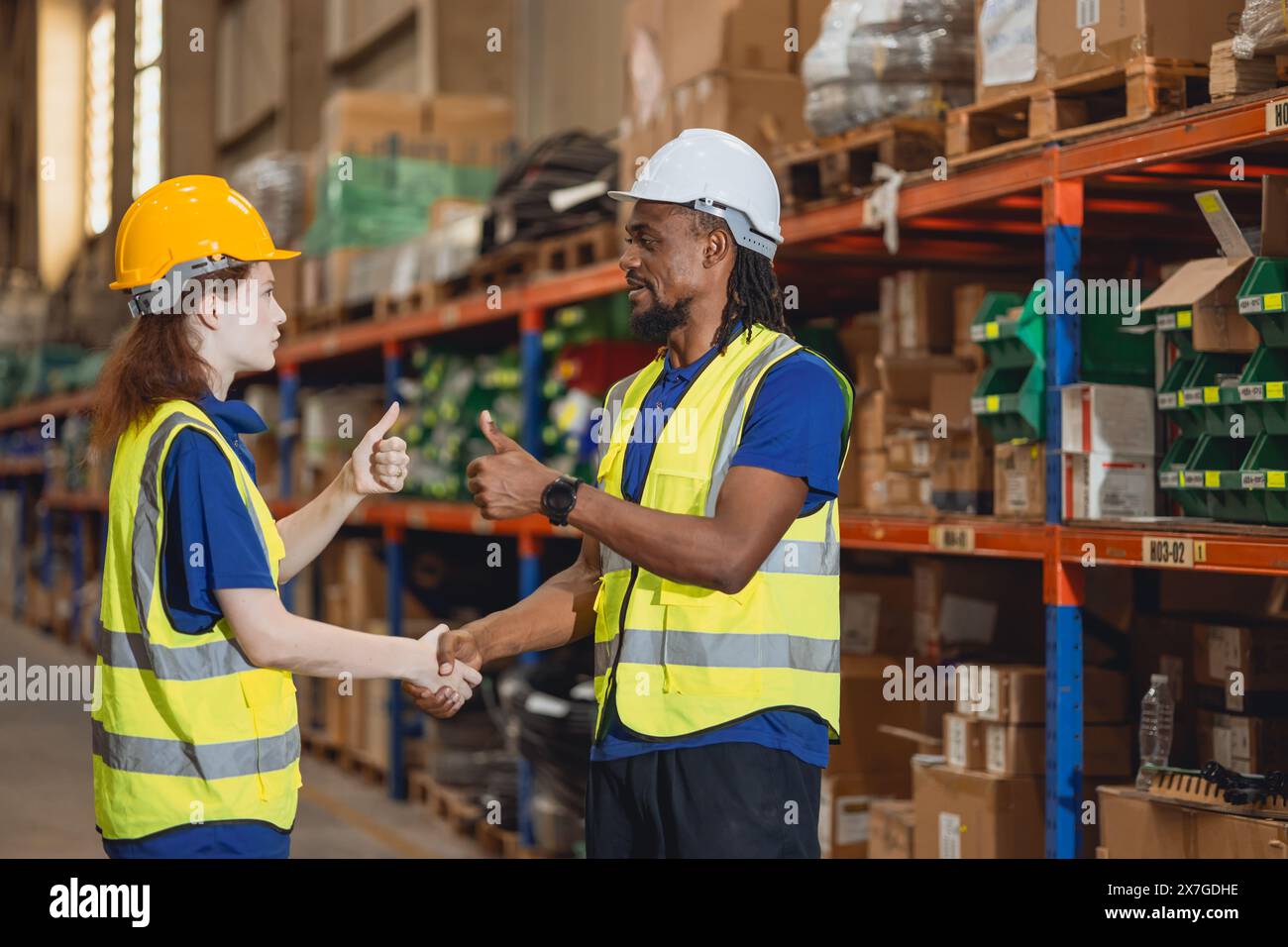 Worker in cargo warehouse teamwork support trainee young women with African foreman help together Stock Photo