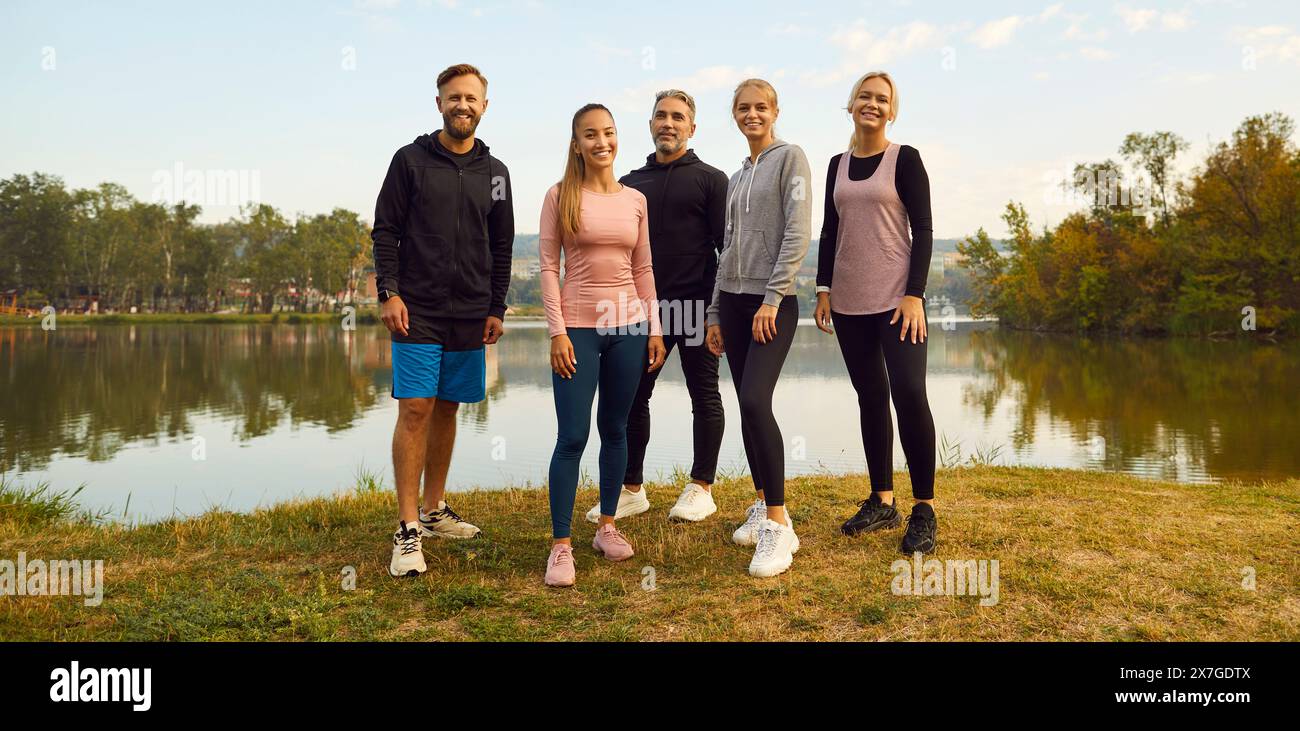 In autumn park group of athletes posing by lake beauty of teamwork ...