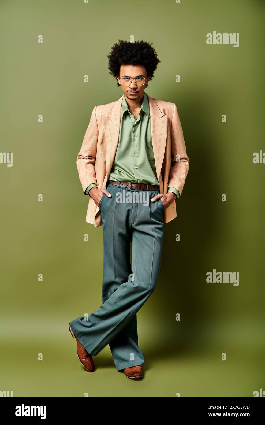 A stylish young African American man with curly hair stands confidently ...