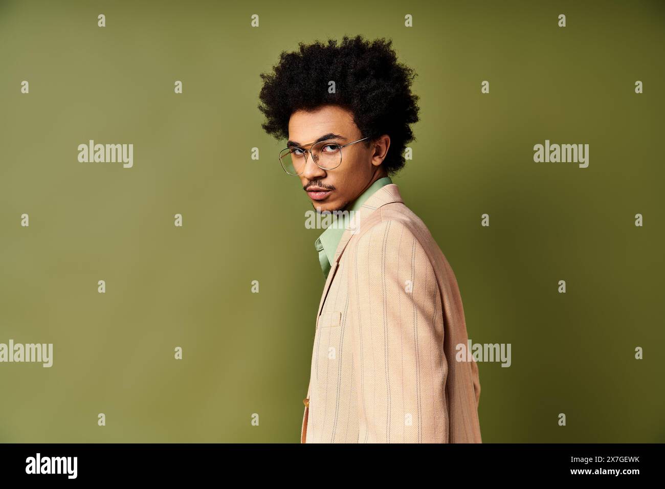 Stylish young man in suit and glasses standing confidently in front of ...