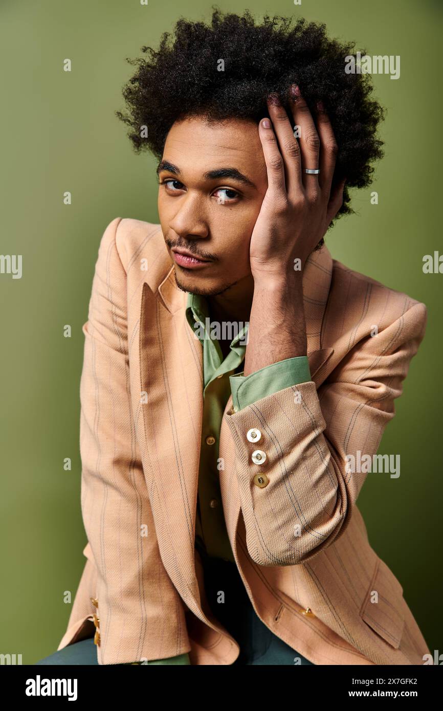 Stylish African American man in a suit sitting with hand on head, deep ...
