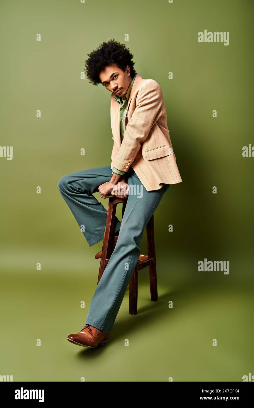 A stylish young African American man in trendy attire sitting on top of ...