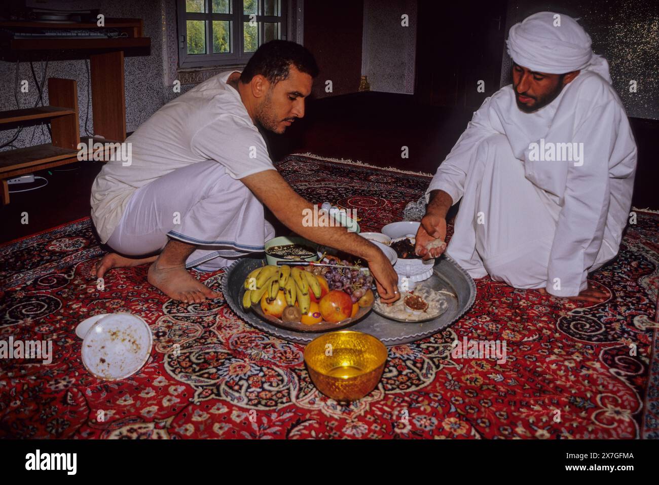 Mudayrib, Oman, Arabian Peninsula, Middle East - Omani Men Taking Lunch on the Eid al-Adha (Feast of the Sacrifice), the annual feast through which Mu Stock Photo