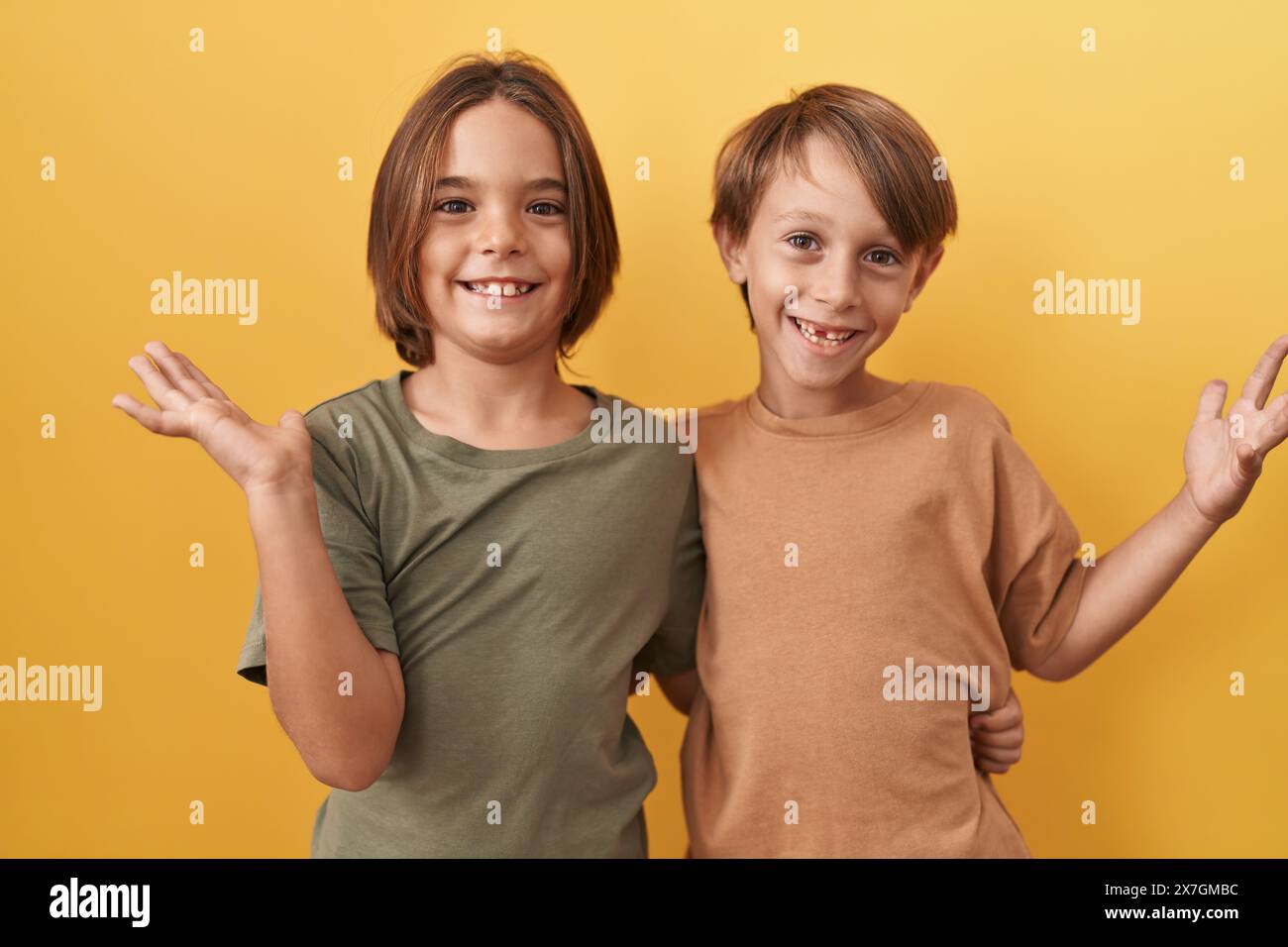 Two cheerful boys standing together, hugging, and celebrating their ...