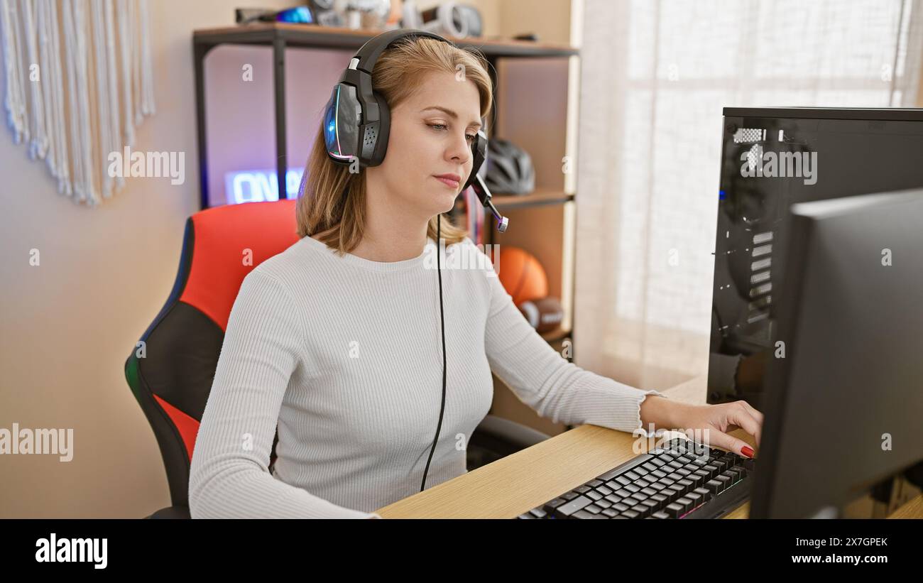 Focused adult woman with short blonde hair and headphones using a ...