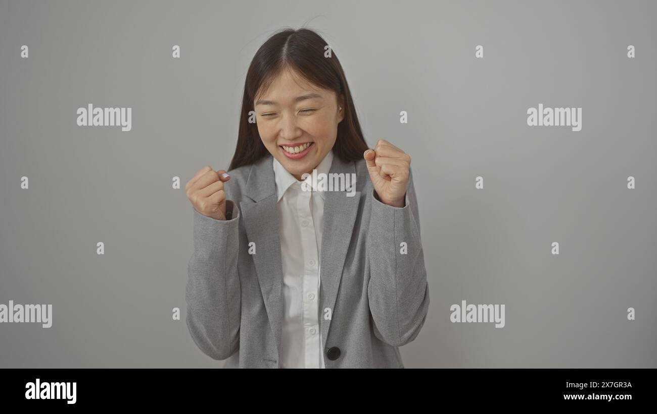 A young asian businesswoman joyously celebrates a success on an ...