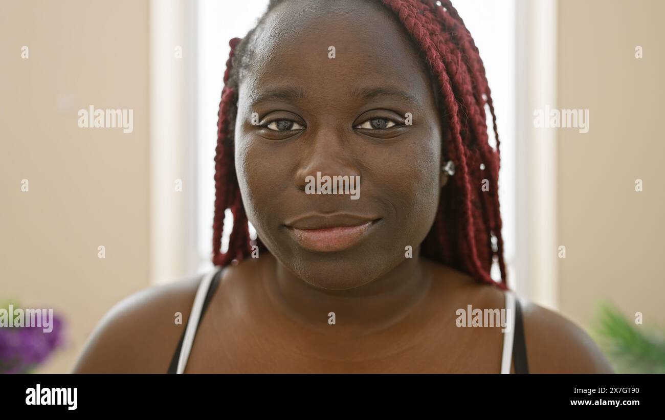 Portrait of a beautiful african american woman with braids indoors at ...