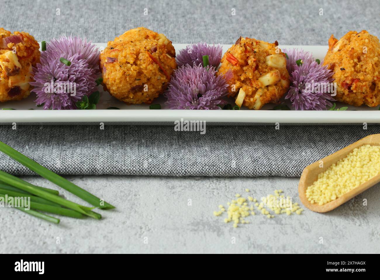 Couscous-Feta Balls with Chive Blossoms on Neutral Grey Background Stock Photo