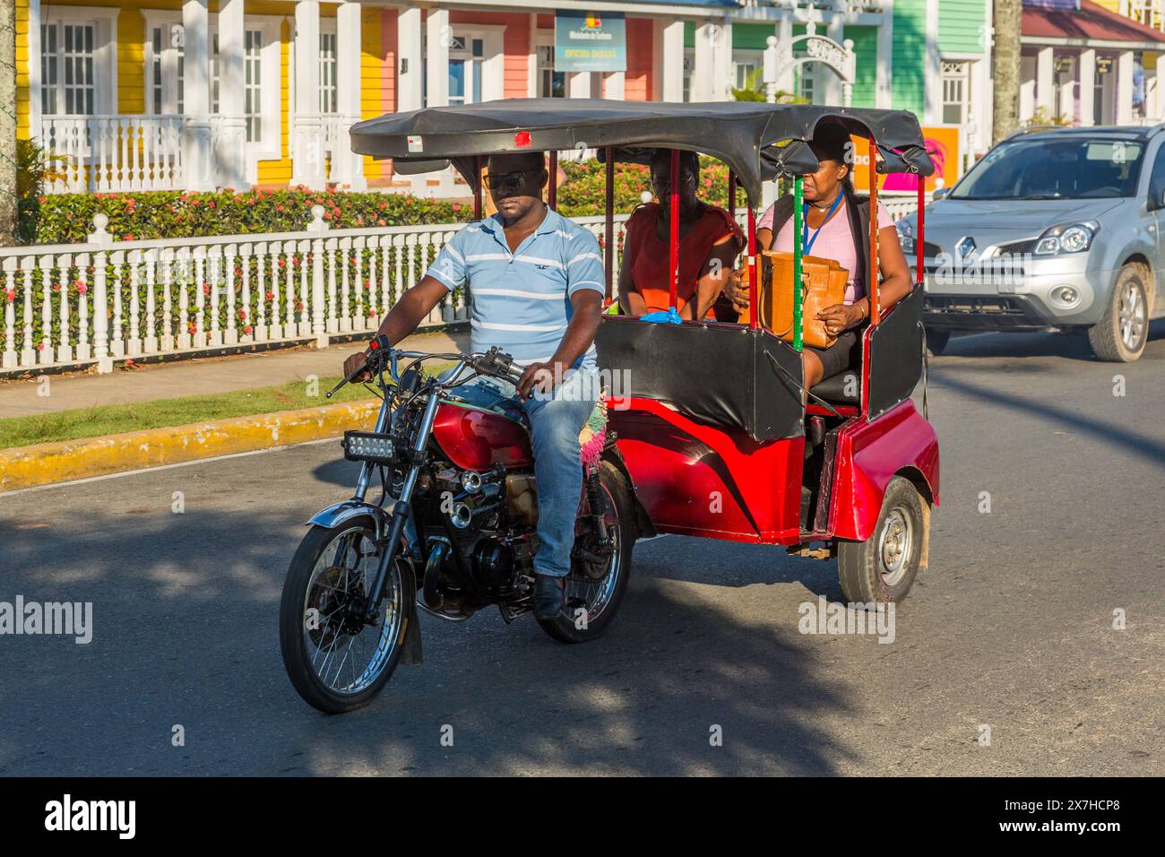 A Dominican motorcycle taxi carrying passengers in Samana, Dominican Republic. Stock Photo