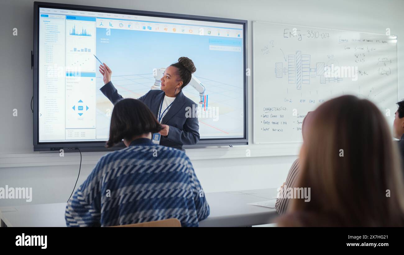 Black Female Teacher Explains Principles of Work With Robotic Arm to Group of Students on Seminar. Specialists Working on Autonomous Facility Optimisation. Robotic Engineering and Science Concept. Stock Photo