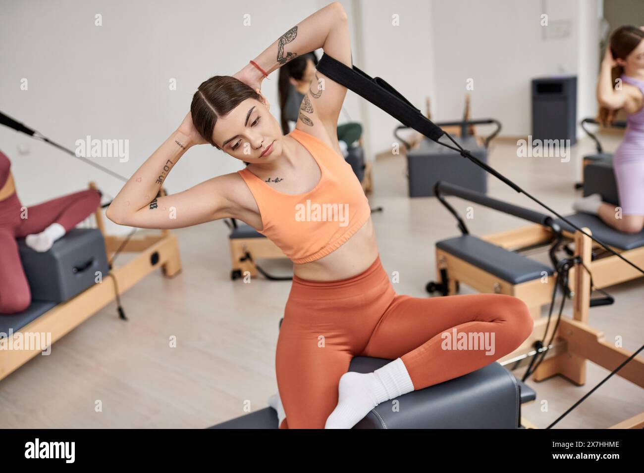 Sporty woman pivots gracefully in pilates class. Stock Photo