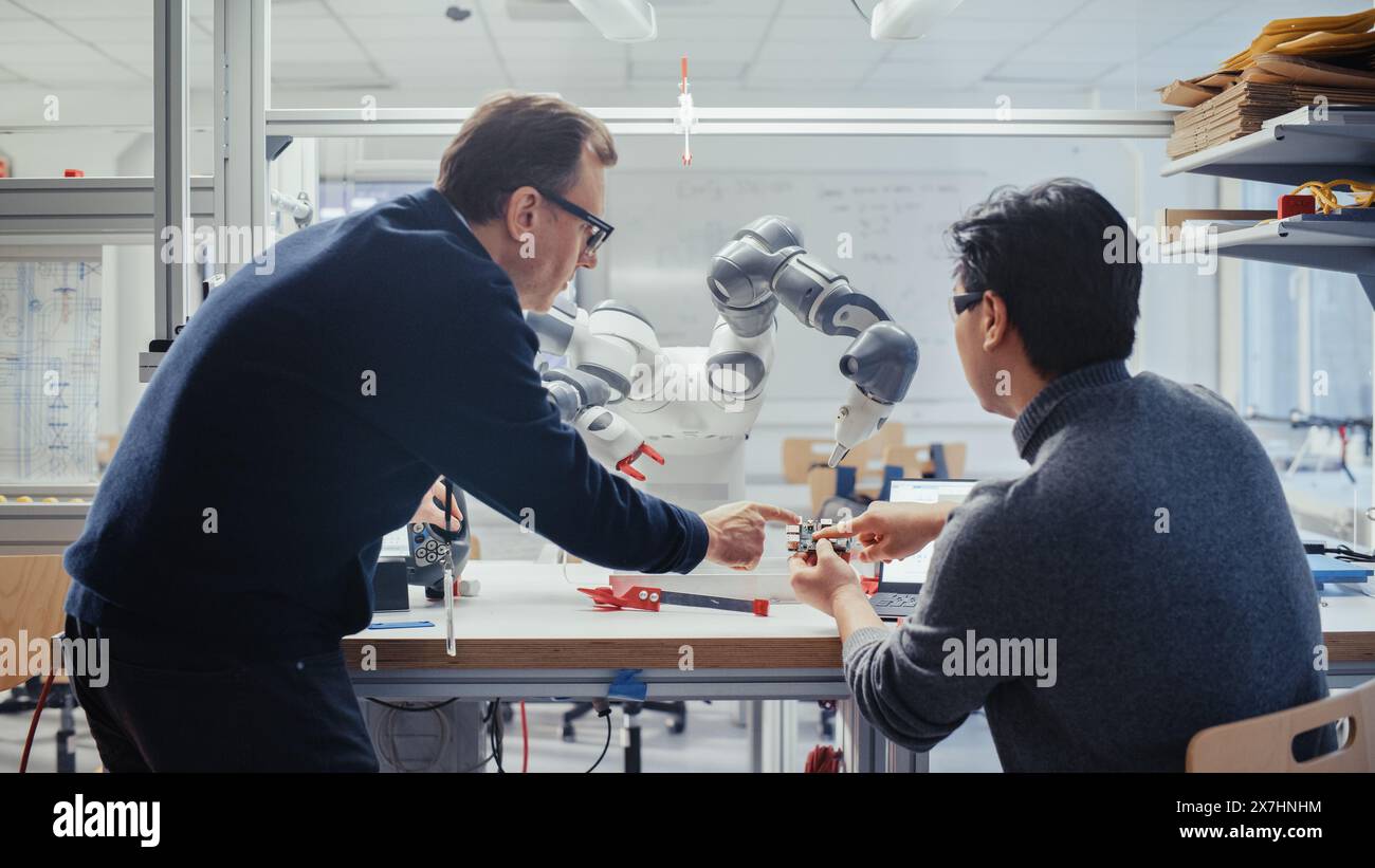 Adult Caucasian Engineer Changes Position of Robotic Arm with ...