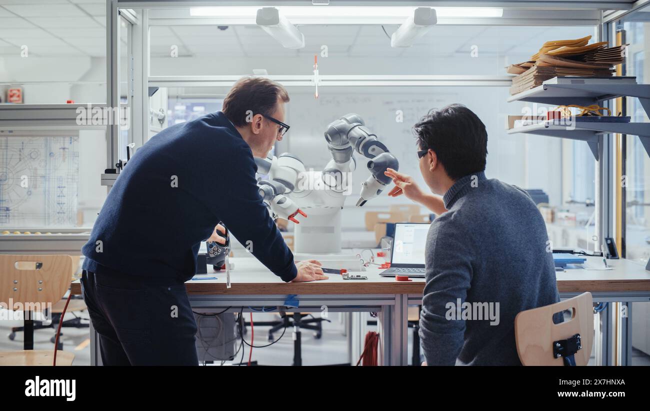 Adult Engineer Changes Position of Robotic Arm with Controller and ...