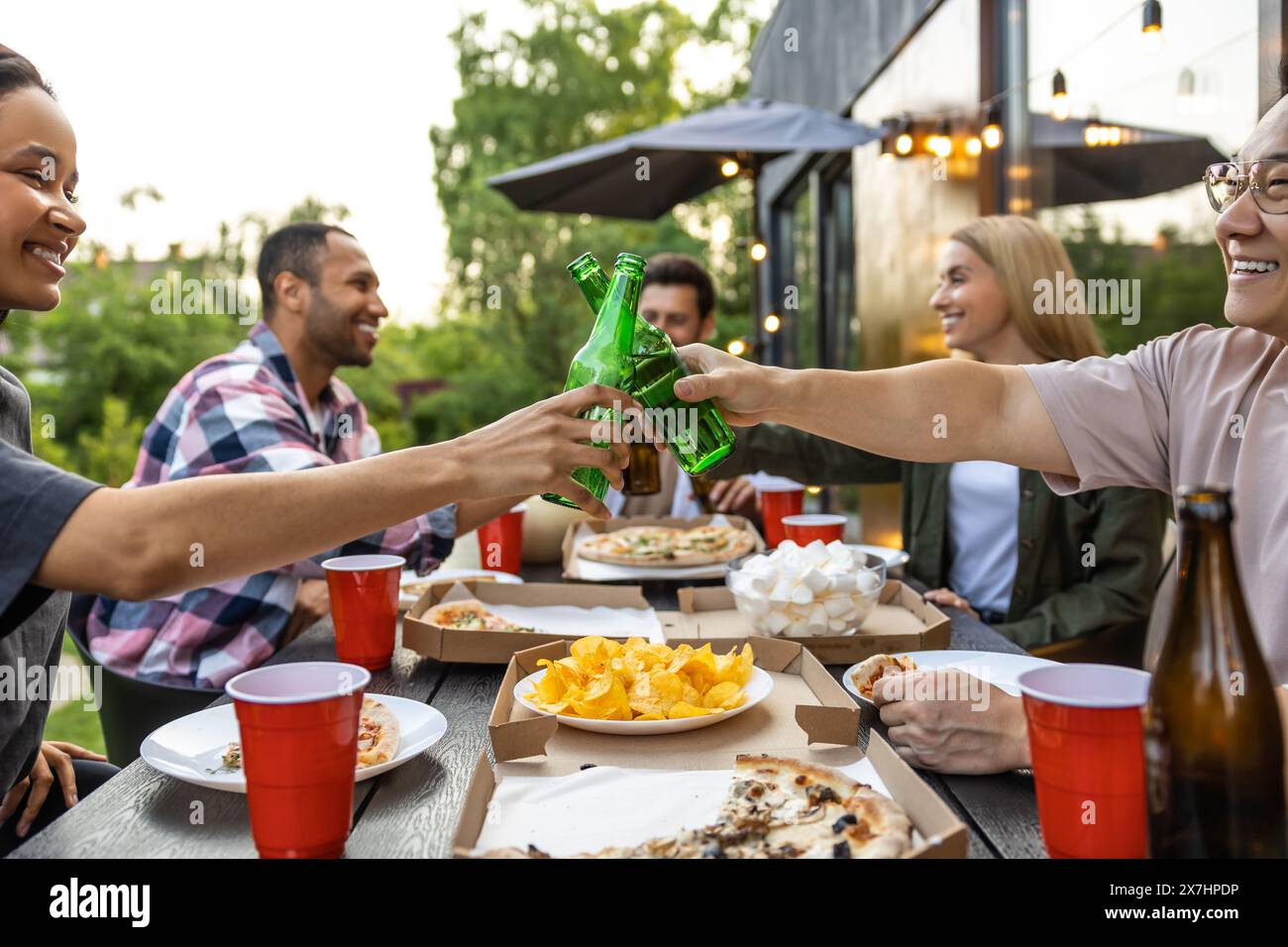 Young people enjoying leisure time together outside toasting with beer Stock Photo