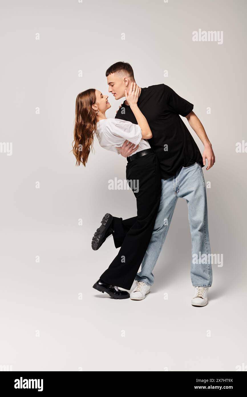 A young couple in love gracefully dance together in a studio, displaying perfect synchronization and mutual admiration. Stock Photo