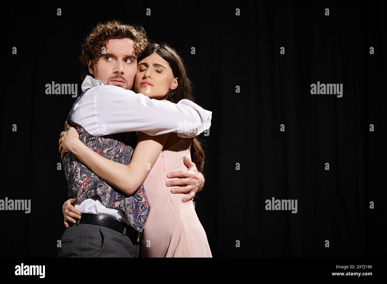 A man tenderly hugs a woman against a black background Stock Photo - Alamy