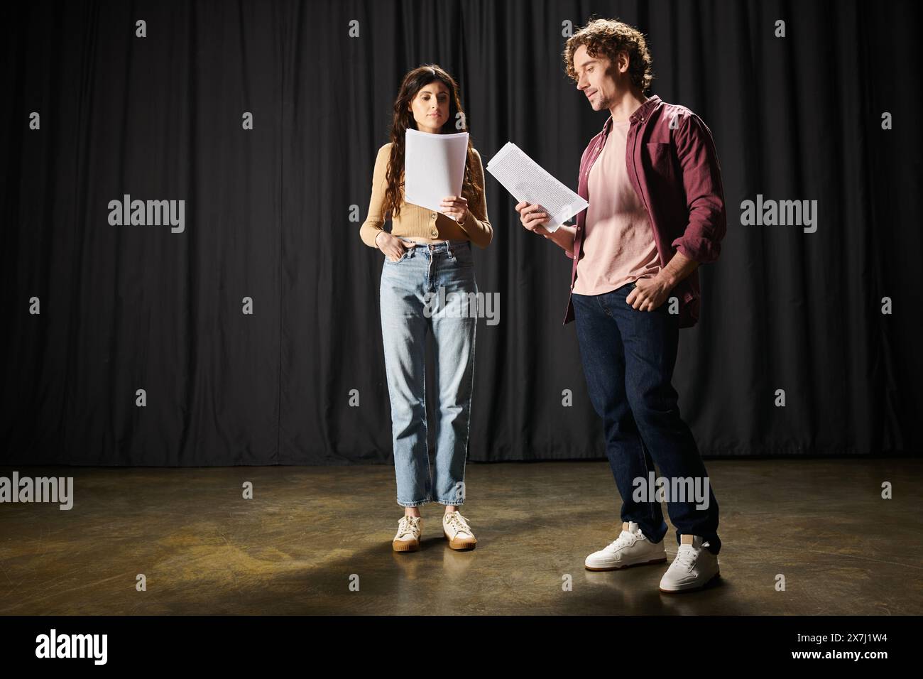 A woman and a man, engrossed in theatrical dialogue, holding a script. Stock Photo