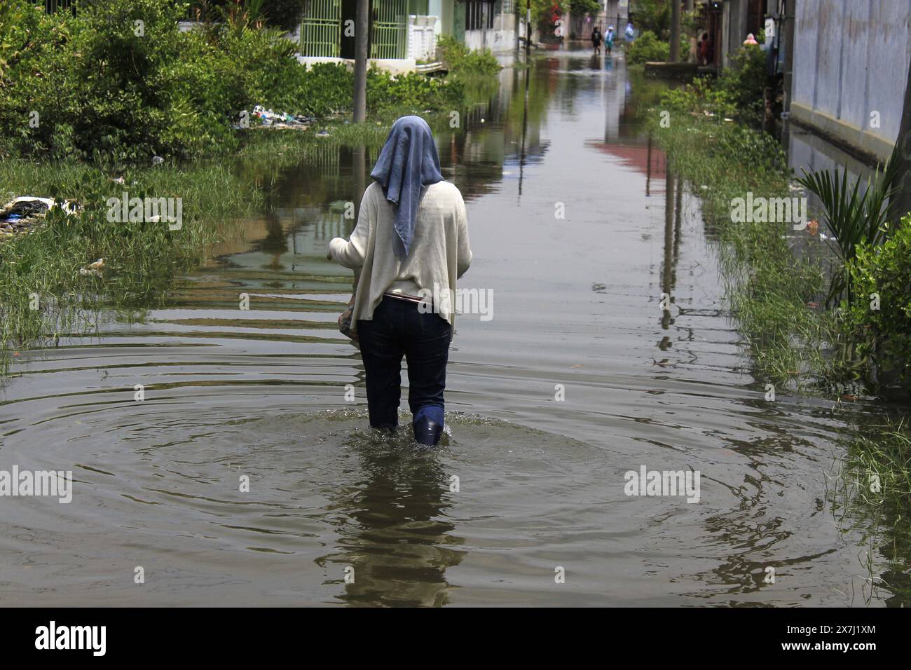 Medan Selayangh, North Sumatra, Indonesia. 20th May, 2024. A resident walks through a flash flood that hit residential areas and disrupted daily activities, in Belawan City, North Sumatra (Credit Image: © Kartik Byma/ZUMA Press Wire) EDITORIAL USAGE ONLY! Not for Commercial USAGE! Credit: ZUMA Press, Inc./Alamy Live News Stock Photo