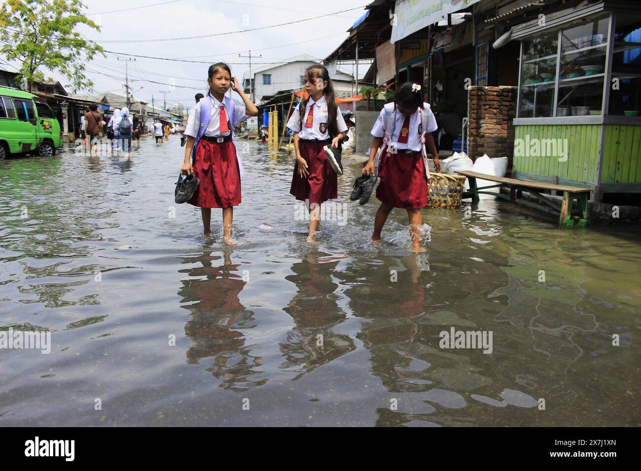 Medan Selayangh, North Sumatra, Indonesia. 20th May, 2024. Three school children were forced to go home with their shoes, because residential areas were submerged in flash floods, due to overflowing sea water. The Meteorology, Climatology and Geophysics Agency stated that flooding in the coastal area of ''‹''‹Belawan City, North Sumatra, Indonesia, is expected to return until May 26 (Credit Image: © Kartik Byma/ZUMA Press Wire) EDITORIAL USAGE ONLY! Not for Commercial USAGE! Credit: ZUMA Press, Inc./Alamy Live News Stock Photo