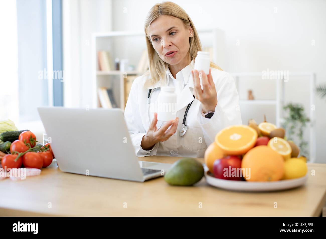 Telehealth and telemedicine concept. Mature nutritionist female doctor explaining medical treatment to the patient through a video conference using la Stock Photo