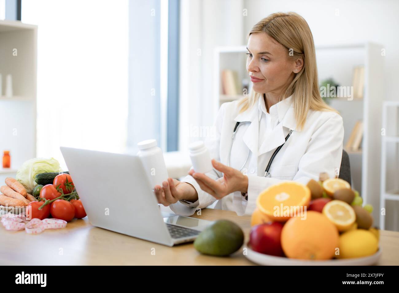 Telehealth and telemedicine concept. Mature nutritionist female doctor explaining medical treatment to the patient through a video conference using la Stock Photo