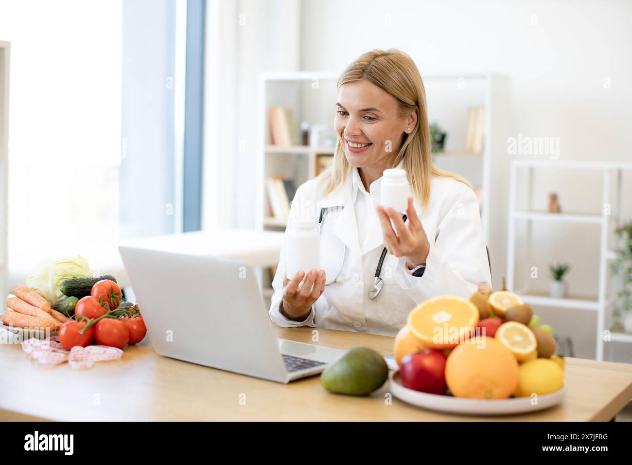 Mature nutritionist female doctor explaining medical treatment to the patient through a video conference using laptop. Telehealth and telemedicine con Stock Photo