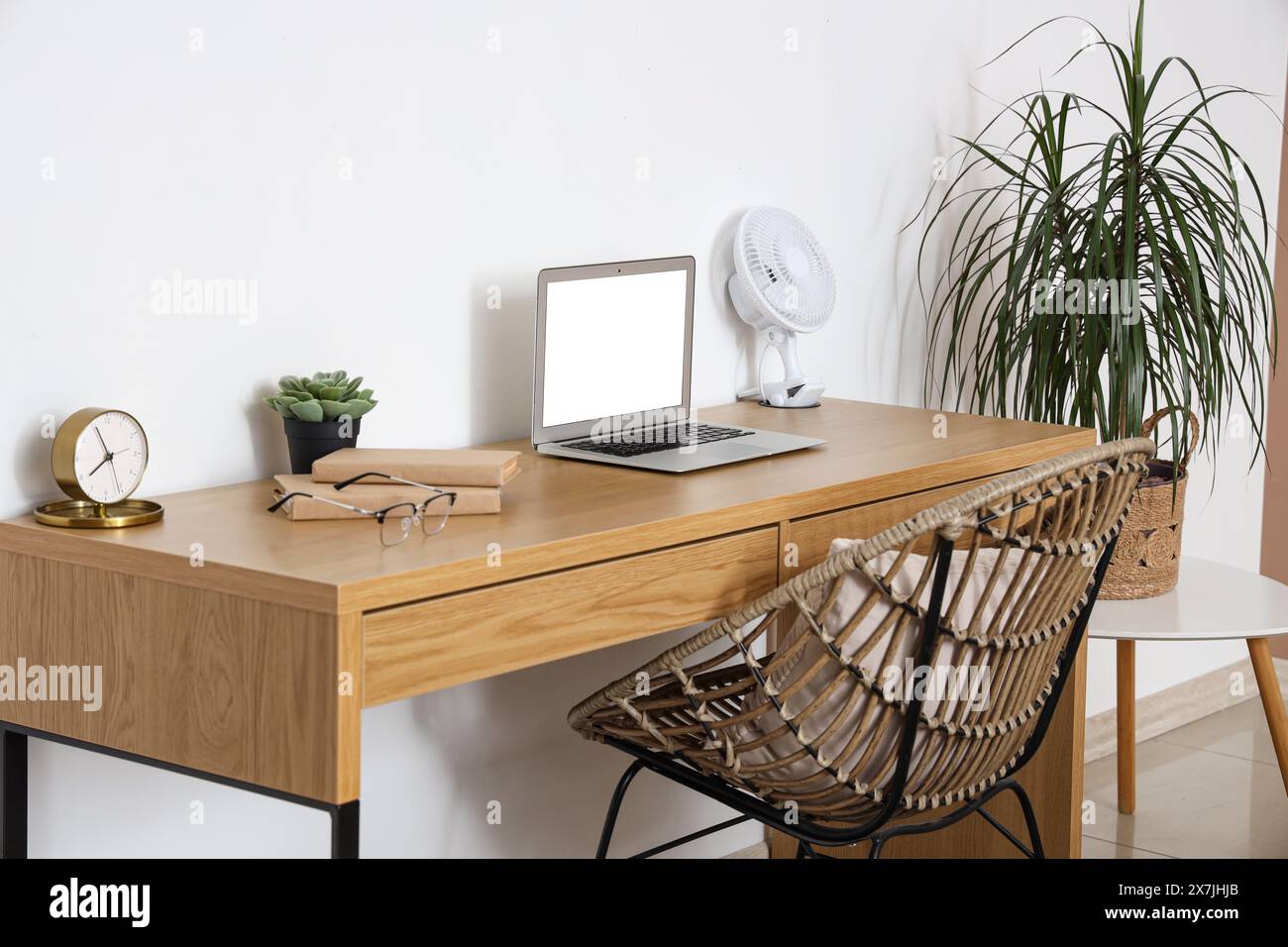 Modern electric fan and laptop on desk at home office Stock Photo - Alamy