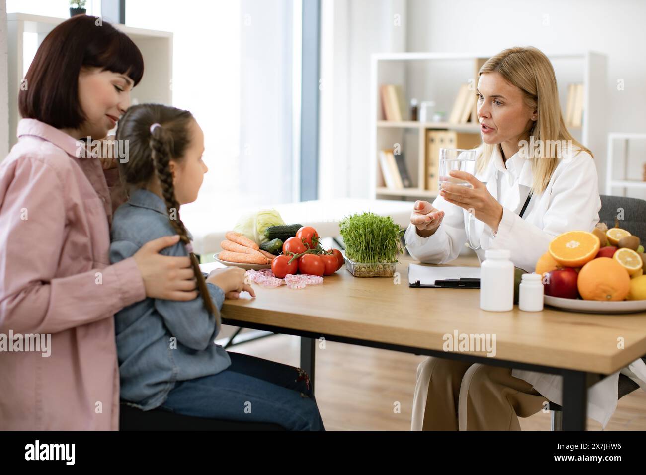 Pediatrician makes treatment plan for diseases of gastrointestinal tract. Mature experienced female nutritionist talks about importance of water balan Stock Photo