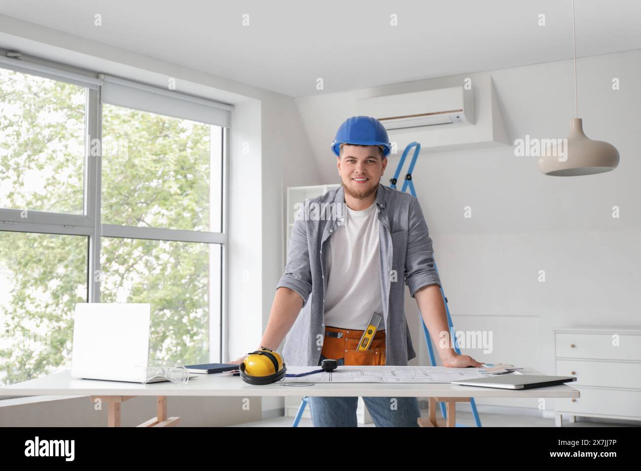 Male contractor working at table in room Stock Photo
