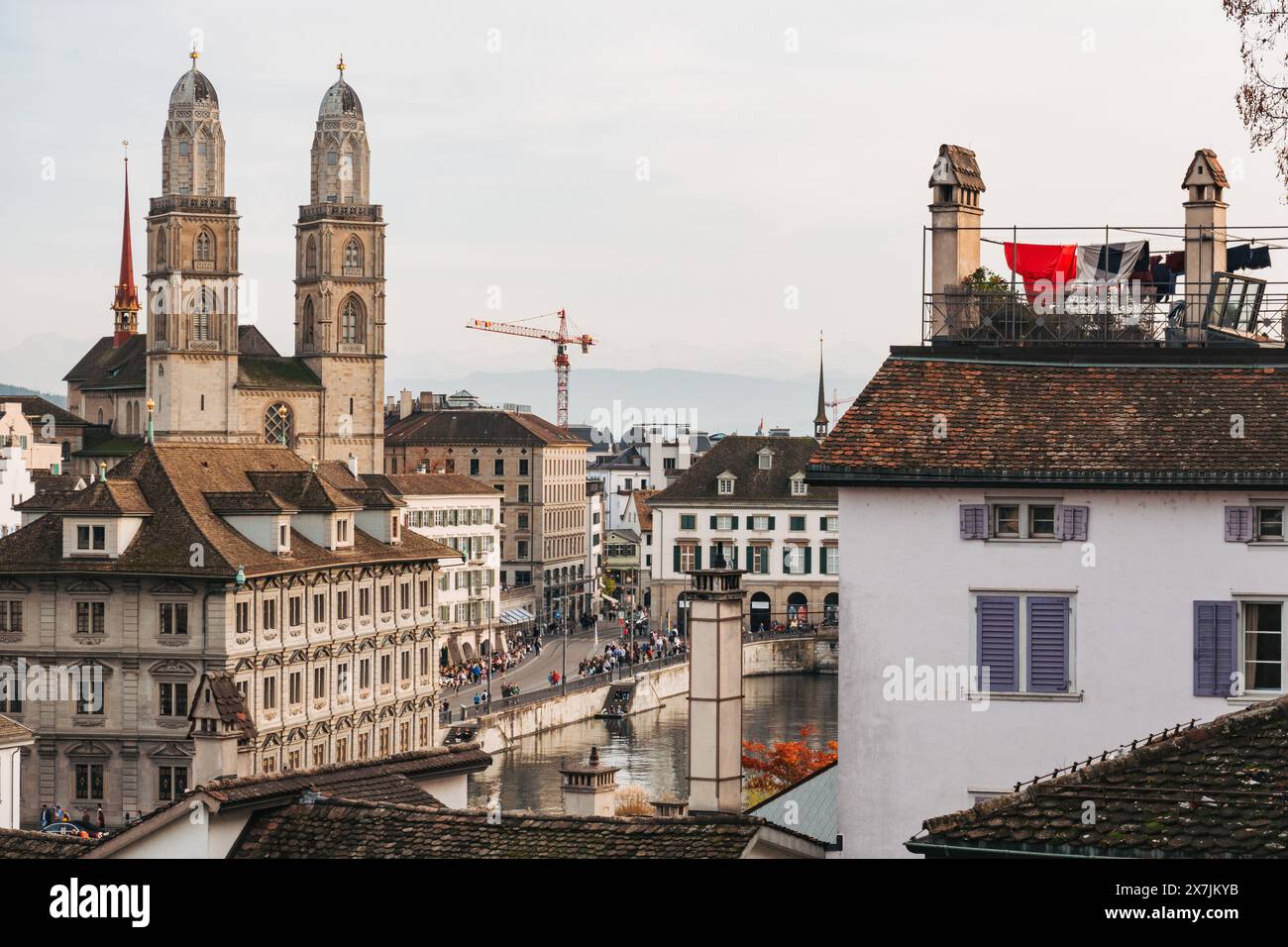 Zurich old town with the Grossmünster church, traditional apartments and laundry drying on a rooftop, near the Limmat river Stock Photo