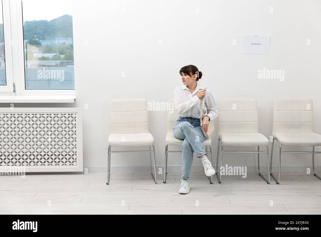 Woman sitting on chair and waiting for job interview indoors Stock Photo