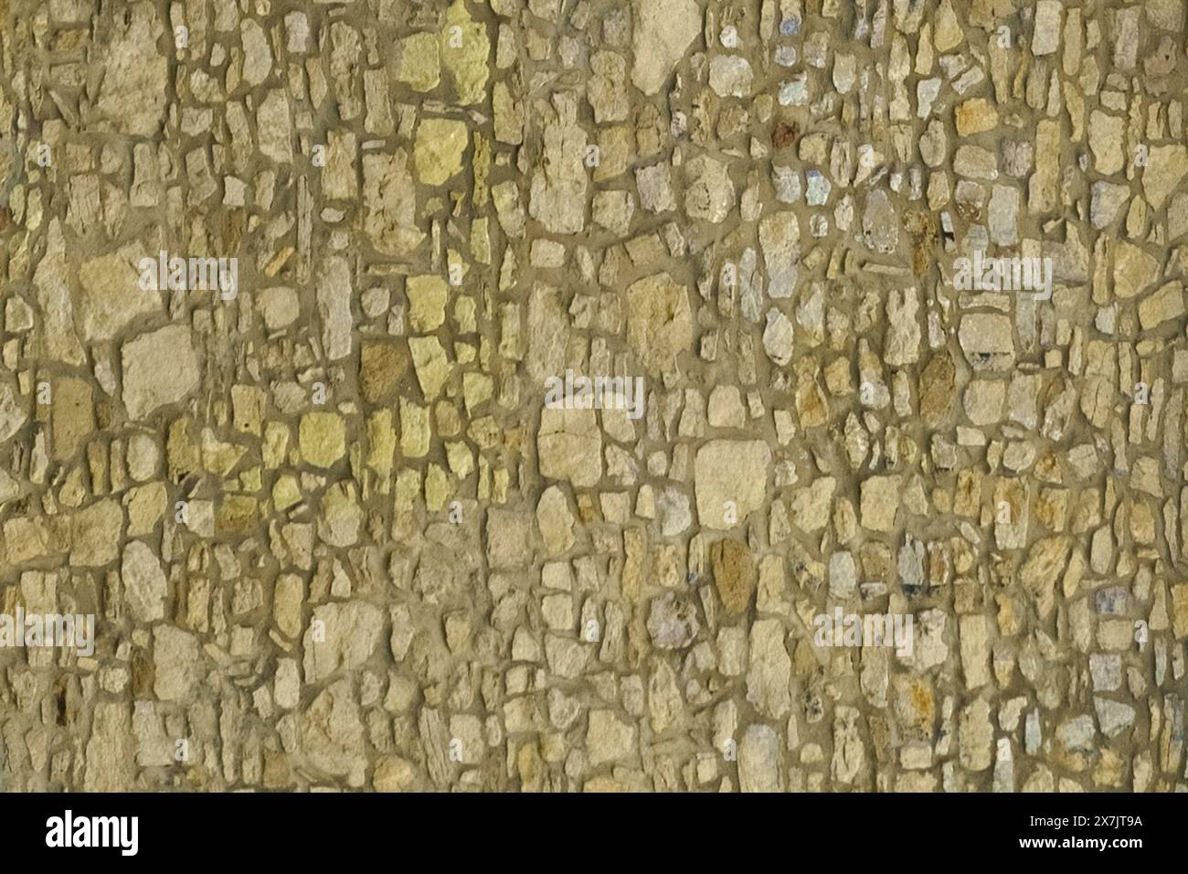 A detailed close up view of a textured stone wall showcasing its unique patterns and rough surface. Stock Photo