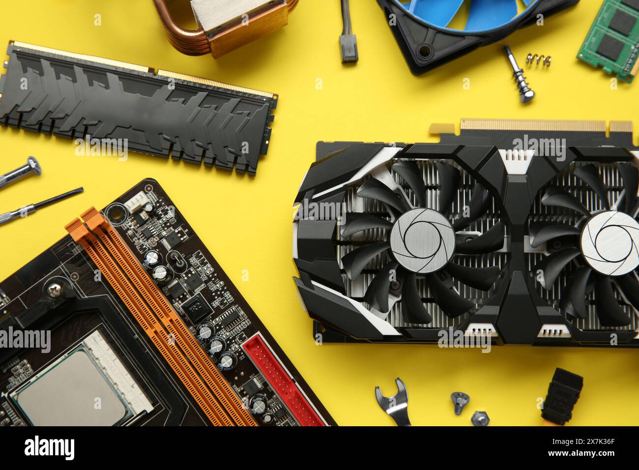 Graphics card and other computer hardware on yellow background, flat lay Stock Photo