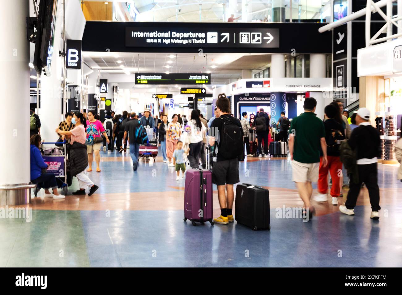 Auckland, New Zealand - February 21, 2024: Travelers inside at the Auckland International Airport. Stock Photo