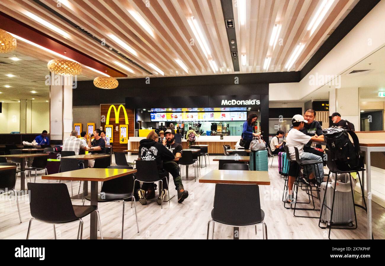 Auckland, New Zealand - February 21, 2024: Travelers dining at McDonald's in the food court located inside Auckland International Airport. Stock Photo