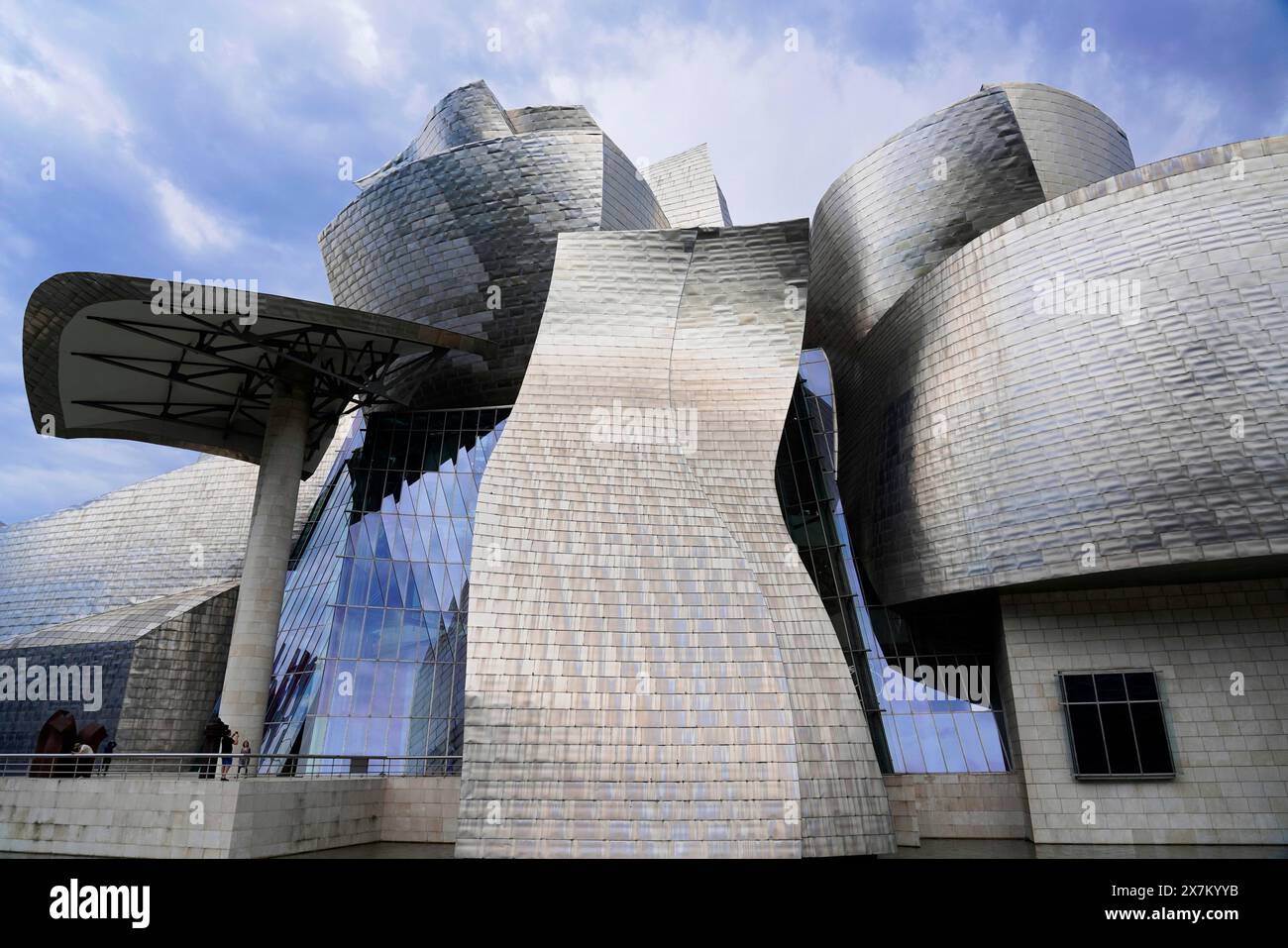 Guggenheim Museum Bilbao, Spain, Europe, The image shows an imposing metal structure with undulating surfaces under a dramatic sky, Guggenheim Museum Stock Photo