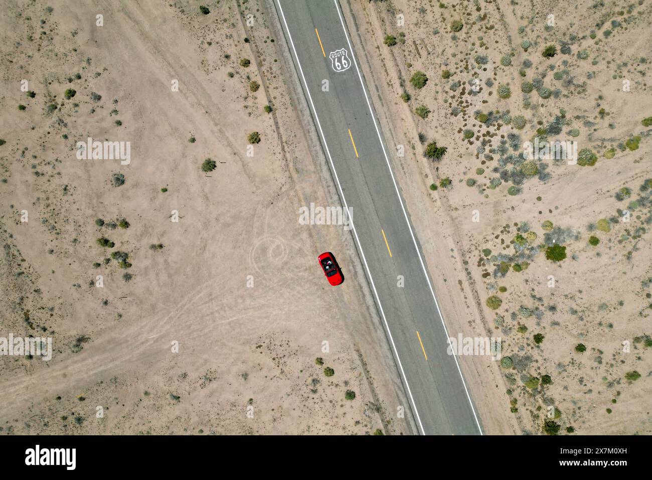 Drone shot of Route 66 with Route 66 sign on the road and red Ford Mustang convertible, Mojave Desert, California Stock Photo