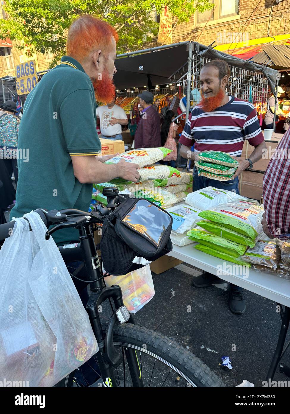 Men with henna colored beards and hair doing business at Bangladeshi street fair in the Kensington section of Brooklyn, New Y Stock Photo