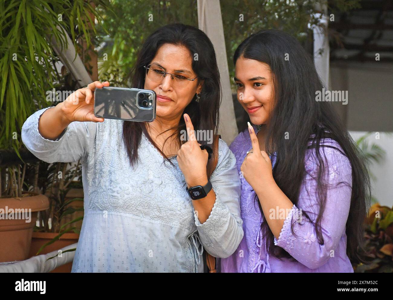 Mumbai, India. 20th May, 2024. A woman and a young lady take a selfie with their inked fingers after casting their vote outside a polling booth in Mumbai. Polling was for six seats of the Loksabha election in Mumbai. These six seats were Mumbai North, Mumbai North West, Mumbai North East, Mumbai North Central, Mumbai South Central and Mumbai South. Maharashtra state recorded a lowest voter turnout of 54 percent. Credit: SOPA Images Limited/Alamy Live News Stock Photo