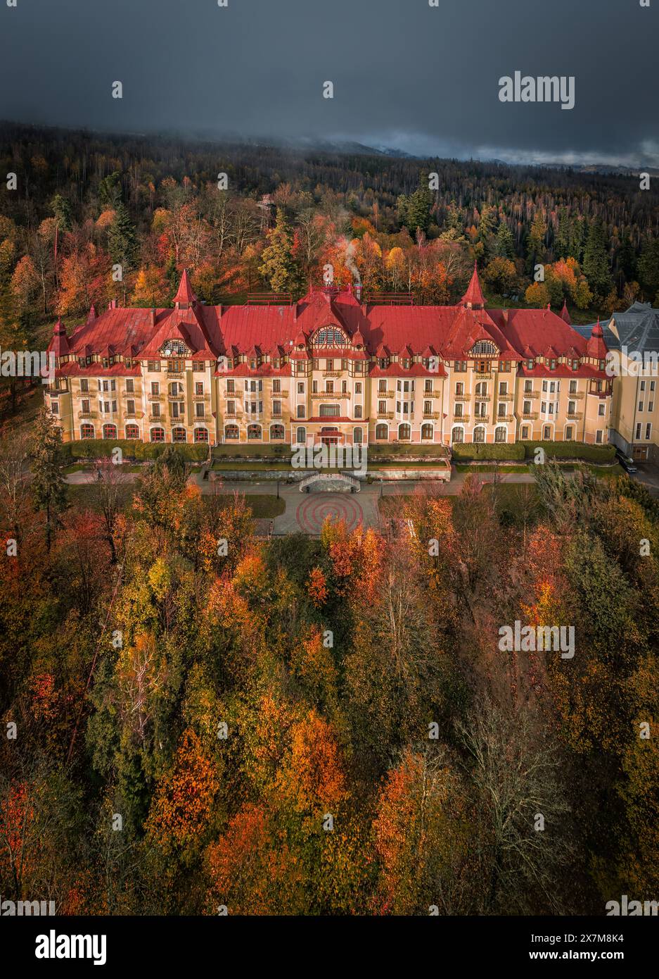 Tatrzanska Lomnica, Slovakia - Aerial view of beautiful warm colorful forest at a hotel by the High Tatras with golden autumn foliage and foggy mounta Stock Photo