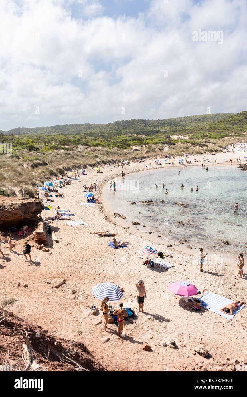 View of Cala Es Tancats in Menorca, Spain. A natural beach with people sunbathing and swimming on a summer day. Tourism in Balearic island Stock Photo